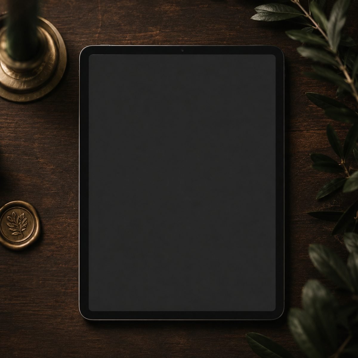 A tablet showing a wedding schedule page, on dark walnut with deep green foliage, a gold candlestick and a wax seal
